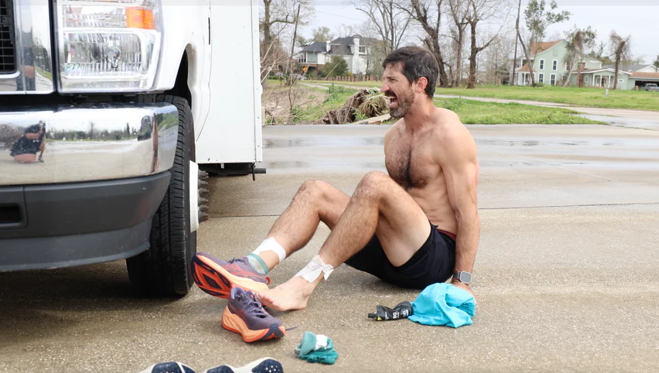 Lachlan sitting beside the camper with his running shoes off.
