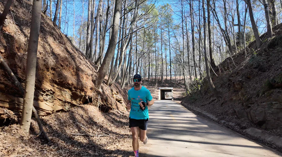 Lachlan running along a paved path between wooded banks.